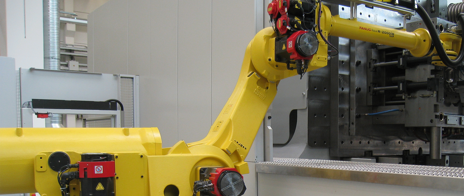 FANUC robot picking part from machine.